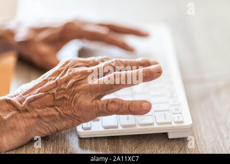 Ältere Frau die Eingabe über die PC-Tastatur Stockfoto
