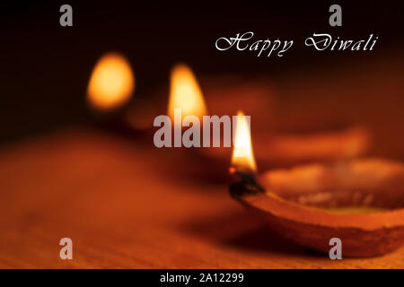 Schönen unscharfen Hintergrund Foto von Diwali Diya oder Öl Ton Lampe mit Happy Diwali Text und kopieren Sie Speicherplatz auf schwarzen Hintergrund isoliert. Stockfoto