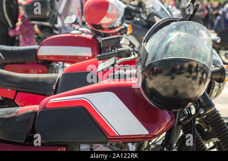 Reihe von Red Vintage Motorcycle Cafés Racer mit Helme in Wettbewerben Nahaufnahme Stockfoto