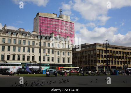 Glasgow Schottland Tauben auf dem George Square Verkehr außerhalb Millennium Hotel und Met Turm mit "Menschen machen Glasgow' Motto hinter Stockfoto