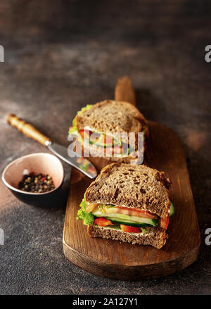 Vorbereitet veganen Sandwiches auf ein Brett und dunklen rustikalen Hintergrund Stockfoto