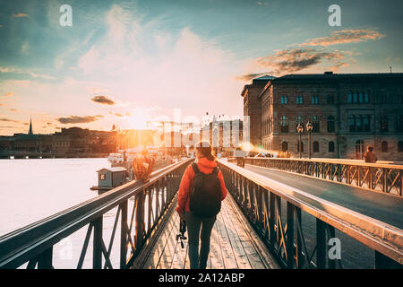 Stockholm, Schweden. Junge kaukasier Frau Lady touristische Reisenden zu Fuß auf der berühmten Brücke Skeppsholmsbron - Skeppsholm. Beliebter Ort, Sehenswürdigkeiten und des Stockfoto