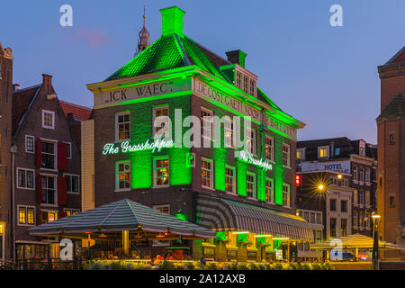 Ein Abend in Amsterdam, mit dem Blick auf die Heuschrecke und die Oude Kerk (Alte Kirche) im Hintergrund, das älteste Gebäude in Amsterdam. Stockfoto