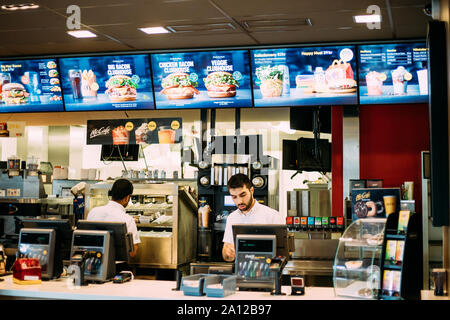 Tocksfors, Schweden - 26. Juni 2019: Migranten Mann steht hinter der Kasse in einem Mcdonalds Restaurant. Mcdonald's Corporation ist der weltweit größte Kette von Stockfoto