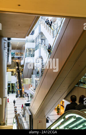 Tokio Haneda Airport. Die zentrale Rolltreppe und Lift Bereich die vier Etagen von Terminal 1 mit Rolltreppen auf beiden Seiten. Menschen. Stockfoto