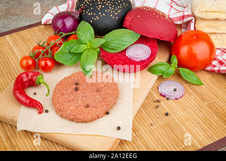 Vegane Burger Kochen Zutat, roh Soja Schnitzel, Brot, Tomaten, Zwiebel Stockfoto