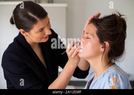 Ein professionelles Make up Artist bei der Arbeit, erstellen einen Blick für eine junge Frau. Stockfoto