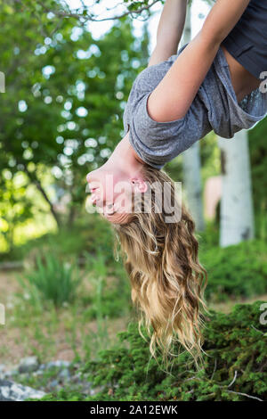 Der 13 Jahre alte Mädchen hing kopfüber vom Baum Stockfoto