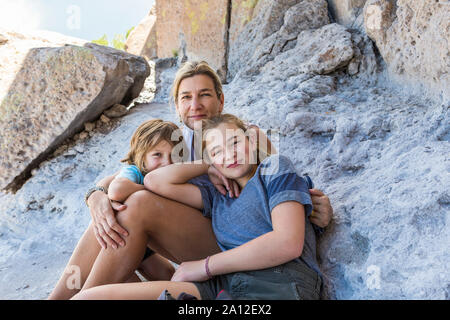 Mutter und ihre Kinder sitzen auf den Felsen, Tsankawi Ruinen, NM Stockfoto