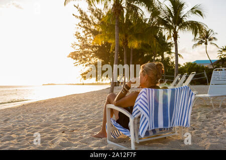 Erwachsene Frau im Strandkorb sitzen, Grand Cayman Island Stockfoto