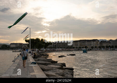 Sonnenuntergang auf der Bains des Pâquis zieht im Sommer Besucher der Quai Du Mont Blanc am Lac Leman (Genfer See) in Genf, Schweiz. Stockfoto