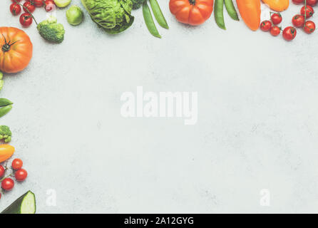 Raw Organic Farm produzieren, Tomaten Gurken salat Pfeffer avocado Frühlingszwiebel Brokkoli Erbsen auf dem weißen Beton Tabelle, Ansicht von oben, Kopieren, getönt, selektiven Fokus Stockfoto