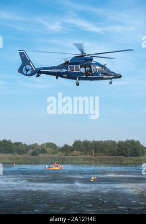 23. September 2019, Niedersachsen, Lassrönne: Bundesamt für Polizei, DLRG und DRK-Wasserwacht Zug wasserrettung an der Elbe mit Hilfe eines Hubschraubers. Das Ziel der Übung ist es, Menschen aus der Luft mit hohem Wasser Standorte oder anderen unzugänglichen Wasser Punkte zu retten. Foto: Daniel Bockwoldt/dpa Stockfoto