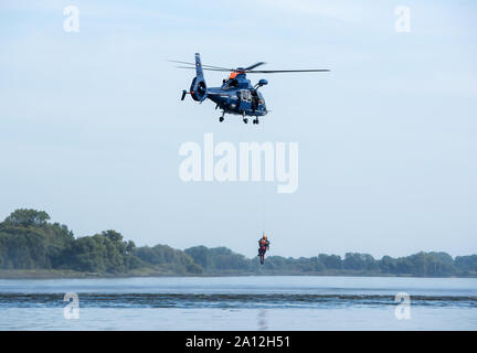 23. September 2019, Niedersachsen, Lassrönne: Bundesamt für Polizei, DLRG und DRK-Wasserwacht Zug wasserrettung an der Elbe mit Hilfe eines Hubschraubers. Das Ziel der Übung ist es, Menschen aus der Luft mit hohem Wasser Standorte oder anderen unzugänglichen Wasser Punkte zu retten. Foto: Daniel Bockwoldt/dpa Stockfoto