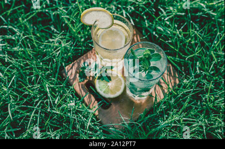 Kaltes Getränk, ein Glas Limonade auf grünem Gras Stockfoto