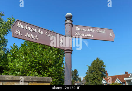 Eine fingerpost auf einem öffentlichen Fußweg in Woking von der Basingstoke Canal Leinpfad, Surrey, England, zeigen Sie auf lokale Orte von Interesse Stockfoto