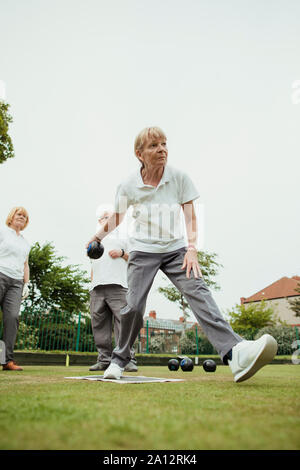 Eine Vorderansicht geschossen von einer älteren Frau, die ihre Aufnahme in ein Spiel der Lawn Bowling. Stockfoto