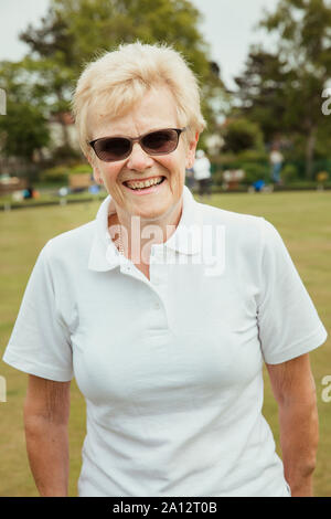 Das Porträt einer älteren Frau an einem bowling green lächelnd. Stockfoto