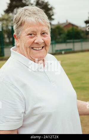 Das Porträt einer älteren Frau an einem bowling green lächelnd. Stockfoto