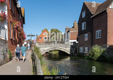 Besucher wandern durch den Fluss Itchen in Winchester Stadtzentrum an einem sonnigen Tag, Hampshire, Großbritannien Stockfoto