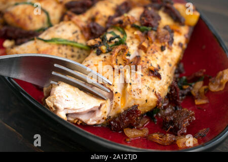 Sun-Dried Tomato Basil Mahi Mahi: eine Platte mit Mahi Mahi Filets mit Sonne gekrönt - getrocknete Tomaten, Basilikum, und Schalotten Stockfoto