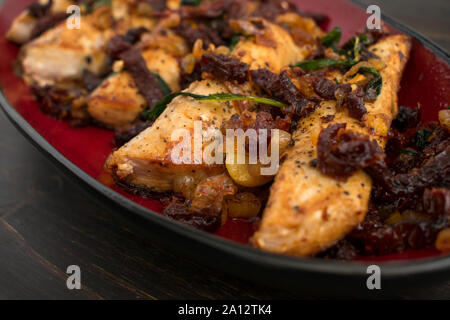 Sun-Dried Tomato Basil Mahi Mahi: eine Platte mit Mahi Mahi Filets mit Sonne gekrönt - getrocknete Tomaten, Basilikum, und Schalotten Stockfoto