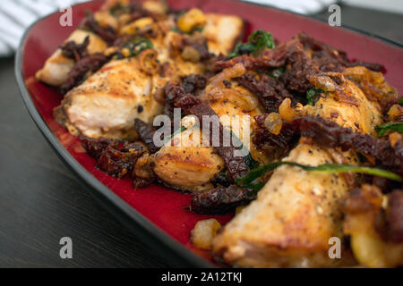 Sun-Dried Tomato Basil Mahi Mahi: eine Platte mit Mahi Mahi Filets mit Sonne gekrönt - getrocknete Tomaten, Basilikum, und Schalotten Stockfoto