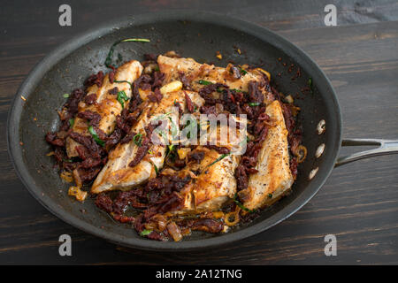 Sun-Dried Tomato Basil Mahi Mahi in einer Pfanne: Gebratene Fischfilets in einer Pfanne mit einer Sonne gekrönt - getrocknete Tomaten Sauce Stockfoto