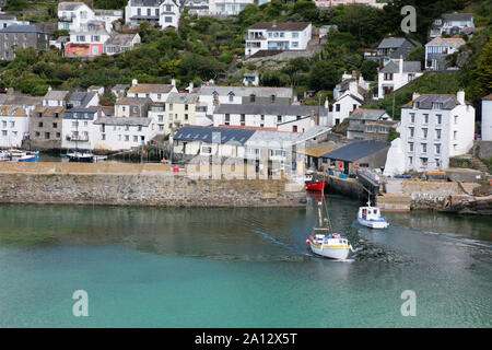 Fischereifahrzeuge, die Verhandlungen über den schmalen Eingang zum Inneren Hafen in Polperro, Cornwall, Großbritannien Stockfoto