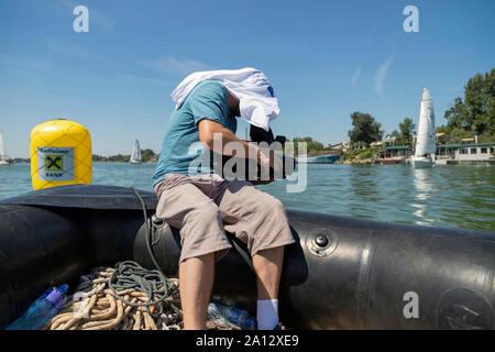 Belgrad, Serbien, 18. August 2019: Mann nimmt die Segelregatta aus einem Schlauchboot auf dem Fluss Sava Stockfoto