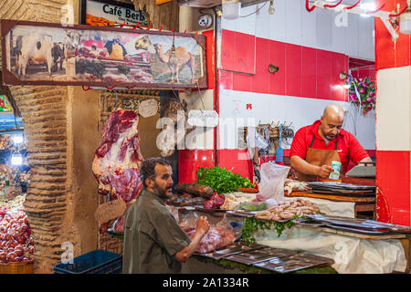 Metzger in Fes Medina Souk Marokko verkauf Kamel Fleisch mit Kamelen Kopf auf Display Stockfoto