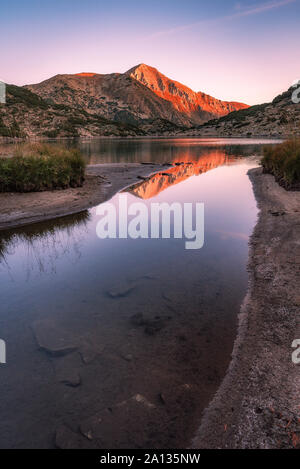 Morgen Sonnenaufgang Blick auf die ribno (Fisch) Banderishko (Banderitsa) See und Vihren peak Reflexion in der Pirin-nationalpark, Bulgarien Stockfoto