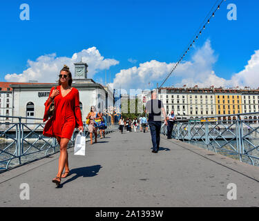 Genf, Schweiz - 29 AUGUST 2019. Mädchen im roten Kleid zu Fuß über die Fußgängerbrücke über den Genfer See und die Rhone im Zentrum von Genf Stockfoto