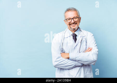 Fröhliche reife Arzt posing und lächelnd an Kamera, Gesundheitswesen und Medizin. Stockfoto