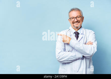 Fröhliche reife Arzt posing und lächelnd an Kamera, Gesundheitswesen und Medizin. Stockfoto