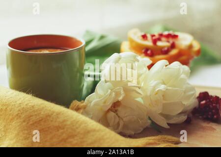 Zarte weiße Blume und Tasse Tee mit Granatapfel Stockfoto