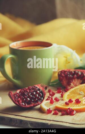 Zarte weiße Blume und Tasse Tee mit Granatapfel Stockfoto