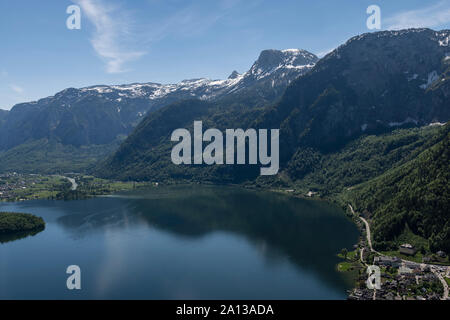 Blick auf den Hallstätter See und Hallstatt ein Teil der Stadt mit den Bergen und einem blauen Himmel im Hintergrund. Stockfoto