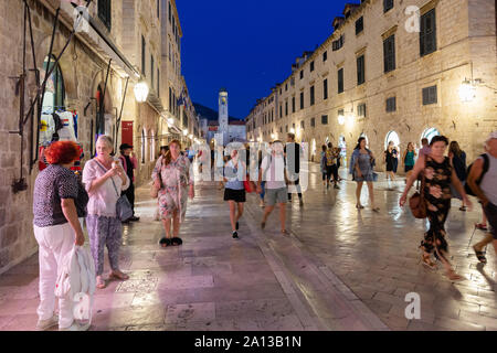 Dubrovnik Street Scene - Menschen zu Fuß auf dem Stradun, Main Street in der Nacht, die Altstadt von Dubrovnik UNESCO Weltkulturerbe Dubrovnik, Kroatien Europa Stockfoto