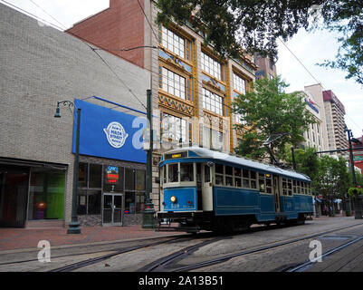 MEMPHIS, Tennessee - Juli 22, 2019: A vibrant Blue electric streetcar Trolley Kreuzfahrten Vergangenheit die kunstvoll geschmückte historische Kress Gebäude auf der Stre Stockfoto