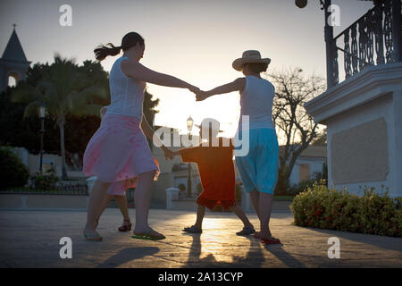 Drei Frauen spielen mit einem Jungen an einem sonnigen Tag. Stockfoto