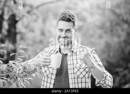 Gesunde Lebensweise. Ich bevorzuge grünen Tee. Erfrischendes Getränk. Man bärtige Kaffee Bauer halten Becher Natur Hintergrund. Grüner Tee Plantage. Vollständige blatt Tee. Angenehmen Moment der Self Care. Natürliche trinken. Stockfoto