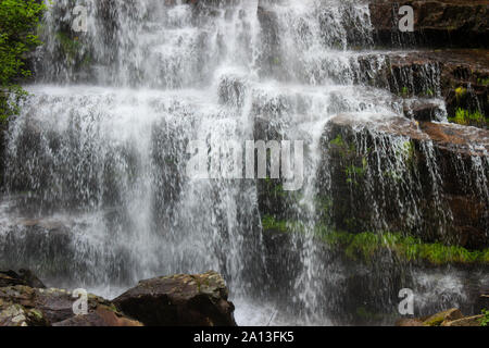 Schöne Nahaufnahme der beeindruckende Wasserfall Tupavica auf alten Berg, in der Nähe von Dojkinci, mit klaren grünen Moos, Spritzwasser und roten Felsen Stockfoto