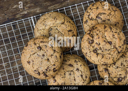 Ein Haufen Chocolate Cookies auf Kühlung Rack. Kekse und ähnliches Kleingebäck, gesüßt. Sie hausgemachte Kuchen. Ansicht von oben. Stockfoto