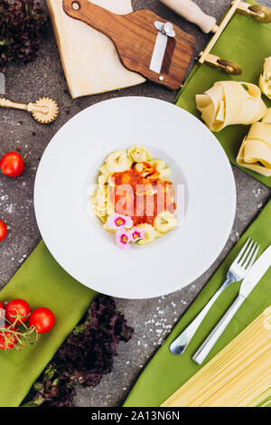 Pasta auf grauem Hintergrund mit Dekorationen für Werbung im Menü. Stockfoto