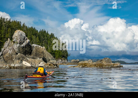 Ein kayaker paddeln unter den gebrochenen Gruppe Inseln im Pacific Rim National Park Reserve, British Columbia, Kanada. Stockfoto