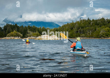 Kayaker paddeln unter den gebrochenen Gruppe Inseln im Pacific Rim National Park Reserve, British Columbia, Kanada. Stockfoto