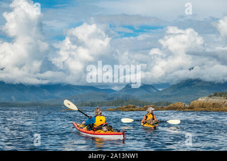 Kayaker paddeln unter den gebrochenen Gruppe Inseln im Pacific Rim National Park Reserve, British Columbia, Kanada. Stockfoto