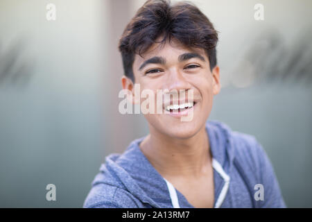 Porträt einer Stattlichen asiatischen jungen Mann neben dem verschwommenen Hintergrund Stockfoto
