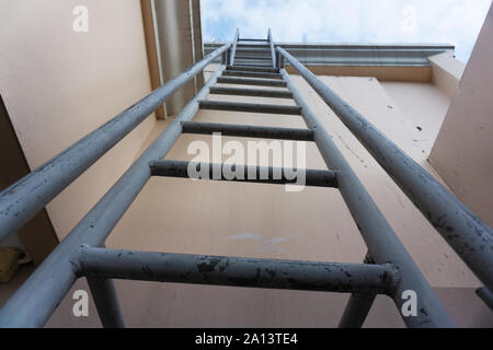 Treppe, die zu einem auf dem Dach eines Gebäudes. Graues metall Treppen, die zum Dach mit Blick auf den schönen Himmel. Stockfoto